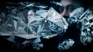 Still frame from 'Bad Boy Billionaires' title sequence. Large diamonds in front of a black background, with images of a man's face in the diamonds' reflections.