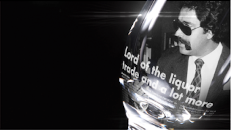 'Bad Boy Billionaires' title sequence style frame 4: close up of a wine glass with a black and white image inside of a man in a suit and sunglasses, with the headline 'Lord of the liquor trade and a lot more' underneath him.