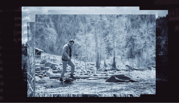 Still frame from The Pursuit launch film. Greyscale photo of a man walking through a clearing in the woods. The edges of other photos can be seen behind the main photo.