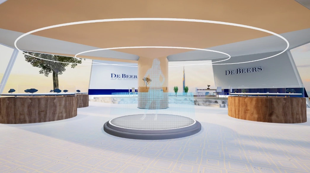 Still frame from De Beers virtual store. In the centre of the shop floor is a circular platform, with a blue holographic silhouette of a woman in the middle. Also seen are surrounding jewellery cabinets and the De Beers logo on the wall.